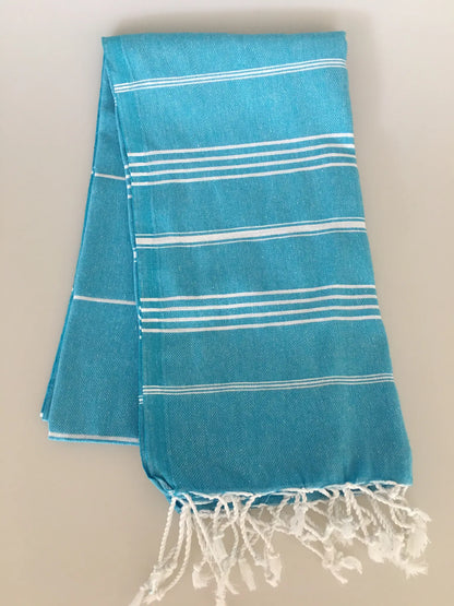 Aphrodisias Sultan Turkish towel peshtemal in vibrant turquoise with white stripes and fringed edges, folded neatly.