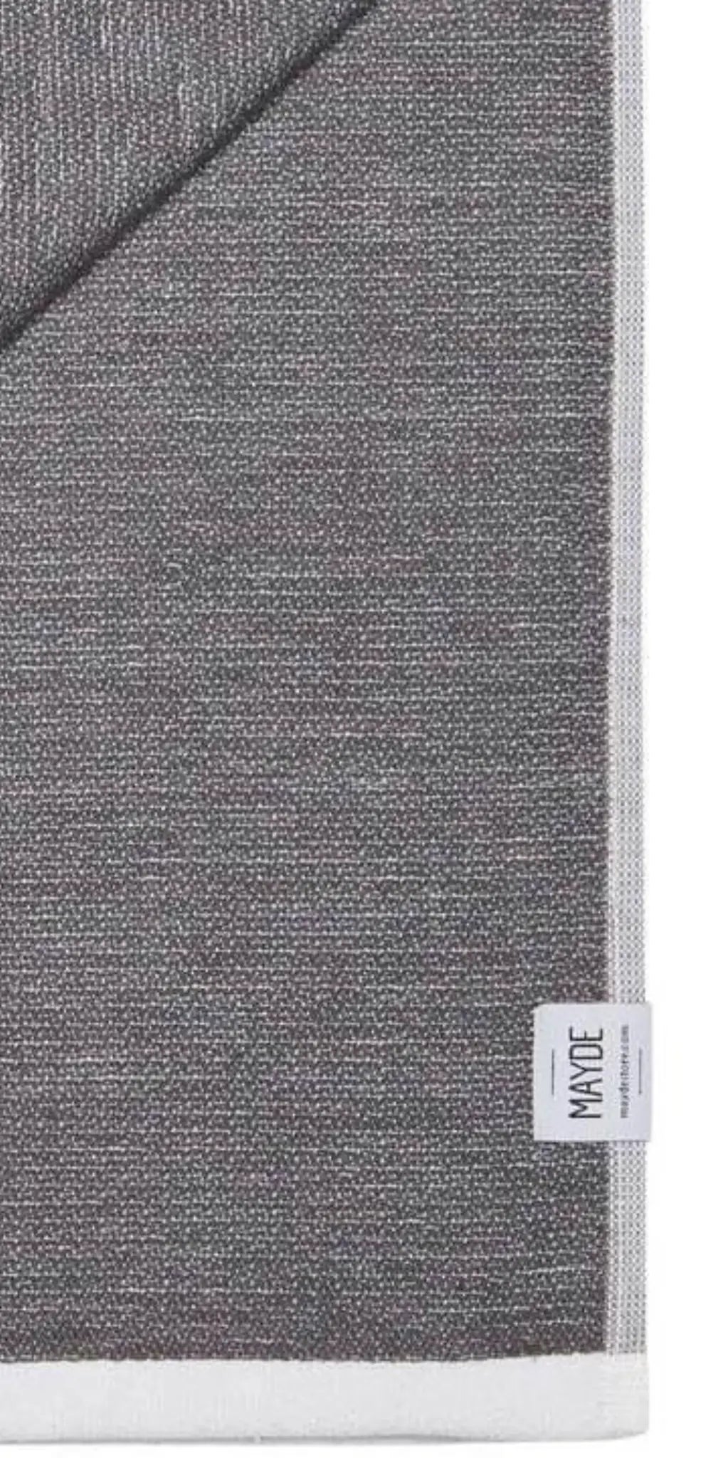 Gray cotton label with a textured pattern, featuring a white edge and a small tag labeled "MADE" at the bottom corner.