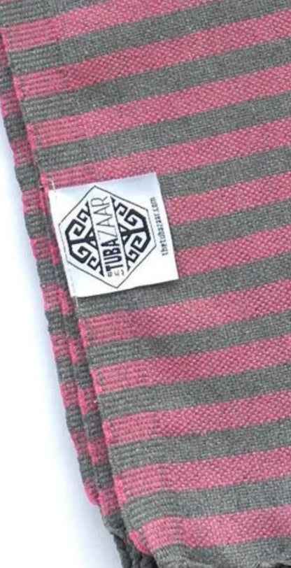"Striped cotton label in pink and gray with a geometric logo, folded corner view on a white background."