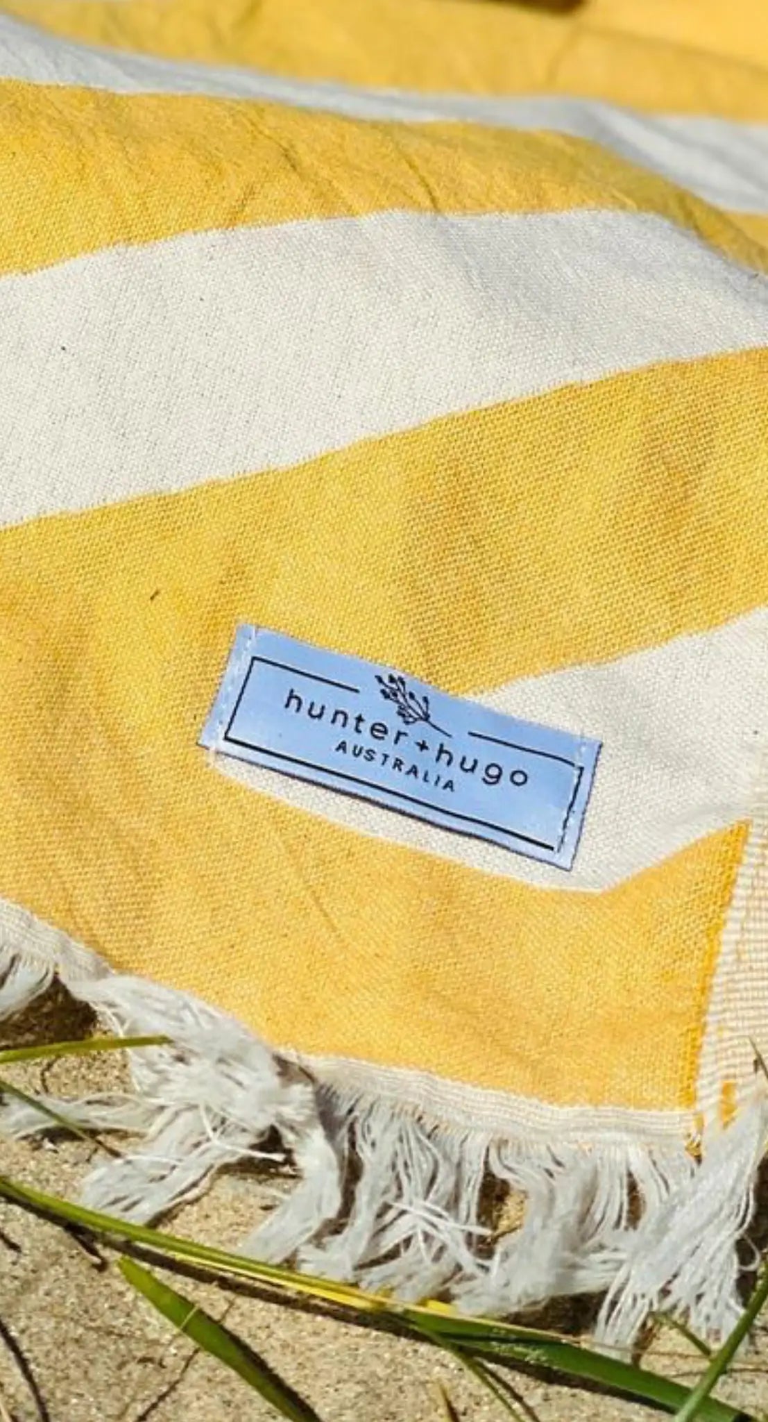"Yellow and white striped cotton label with fringe edges, featuring 'hunter + hugo AUSTRALIA' tag."